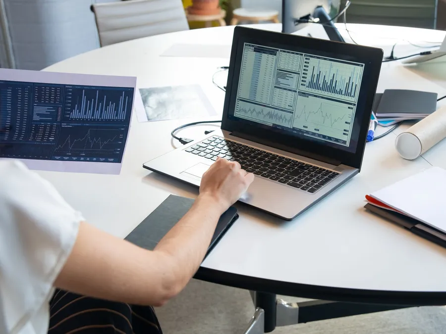 Analista revisando reportes y gráficas de riesgo en una laptop
